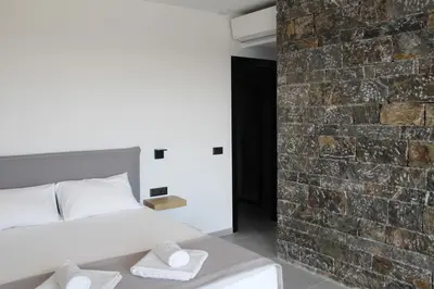 a bedroom with a bed and a brick wall at Astrokastro Frangokastello in Frangokastello