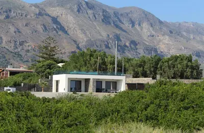 a white house with mountains in the background at Astrokastro Frangokastello in Frangokastello