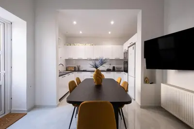 a dining room with a black table and yellow chairs at Apanemia Apartment in Chania Town