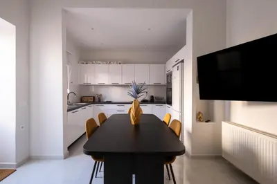 a kitchen with a black table with chairs and a tv at Apanemia Apartment in Chania Town