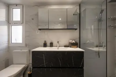a white bathroom with a sink and a toilet at Apanemia Apartment in Chania Town