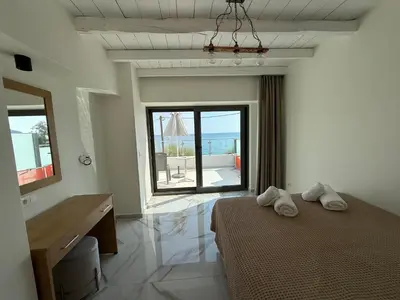 a bedroom with a bed and a view of the ocean at Phoenix Coastal Heaven in Loutro