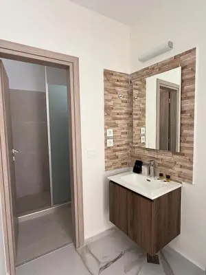 a bathroom with a sink and a mirror and a shower at Phoenix Coastal Heaven in Loutro