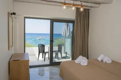 a bedroom with a bed and a view of the ocean at Phoenix Coastal Heaven in Loutro