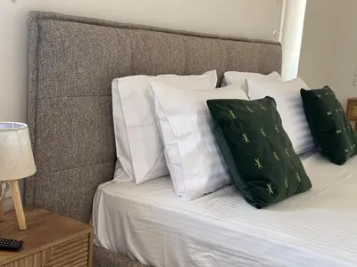 a bed with green and white pillows on it at Casa Ansia Luxury Living 50m from the Beach in Stalos