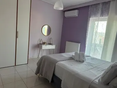 a purple bedroom with a bed and a window at Casa Ansia Luxury Living 50m from the Beach in Stalos