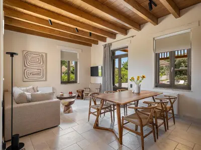 a living room with a wooden table and chairs at Armenaki Residence in Arménoi