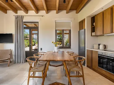 a kitchen and dining room with a wooden table and chairs at Armenaki Residence in Arménoi