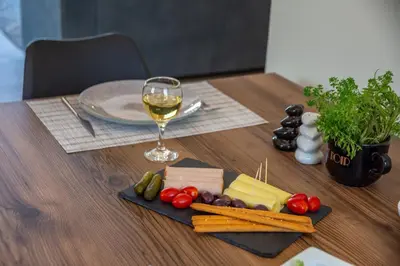 a wooden table with a glass of wine and cheese at Villa Alma Libre Kissamos in Kissamos