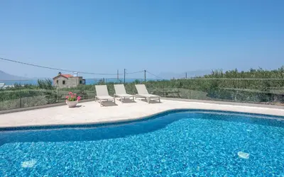 a swimming pool with two lounge chairs and a house at Villa Alma Libre Kissamos in Kissamos