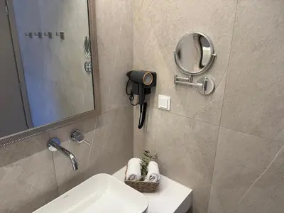 a bathroom with a sink and a mirror and a phone at Sunrise Village Aptera Private Pool Villa in Beritianá