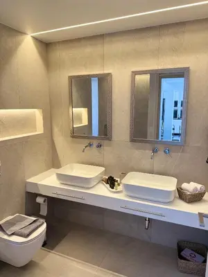 a bathroom with two sinks and a toilet and mirrors at Sunrise Village Aptera Private Pool Villa in Beritianá