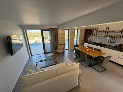 a living room with a couch and a table at Sunrise Village Aptera Private Pool Villa in Beritianá