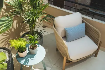 a chair and a table on a balcony with plants at Old Town Apt, Balcony, brand new, family, central in Chania Town