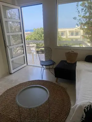 a living room with a bed and a glass table at andys house in Chania