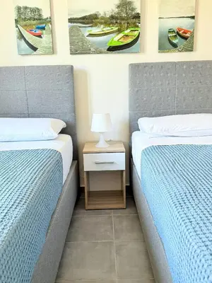 two beds sitting next to each other in a bedroom at Fifty Shades of Blue 10 sec to sea 5PL 2BD 2BA in Stalos