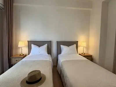 two beds with a hat sitting on top of them at Kalliso City Apartment near the beach in Chania Town