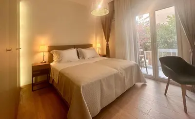 a bedroom with a bed and a window and a chair at Kalliso City Apartment near the beach in Chania Town