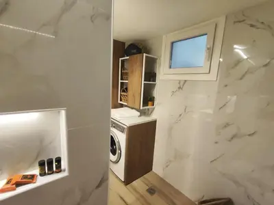 a bathroom with a washer and dryer in a room at Kalliso City Apartment near the beach in Chania Town