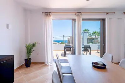 a dining room with a table and a view of the ocean at Kalamaki Del Mar in Chania Town