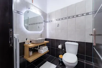 a bathroom with a toilet and a sink and a mirror at Kalamaki Del Mar in Chania Town