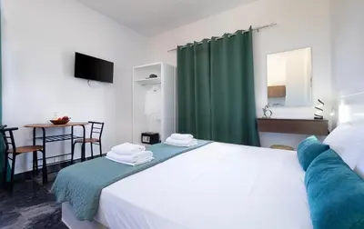 a bedroom with a bed with a green shower curtain at Anastasia Veridian Living in Kalathas