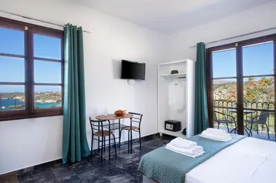 a bedroom with a bed and a table with a view at Anastasia Veridian Living in Kalathas