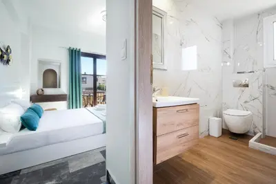 a white bathroom with a sink and a toilet at Anastasia Veridian Living in Kalathas