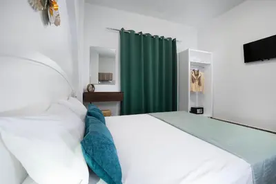 a bedroom with a white bed and a green curtain at Anastasia Veridian Living in Kalathas