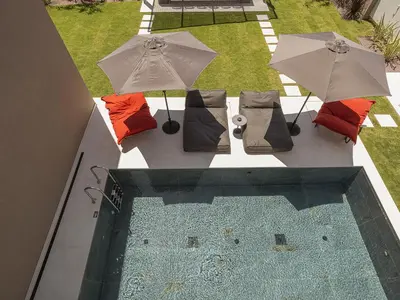 an overhead view of a swimming pool with umbrellas and chairs at Villa Azahar Serene Luxury Living in Milonianá