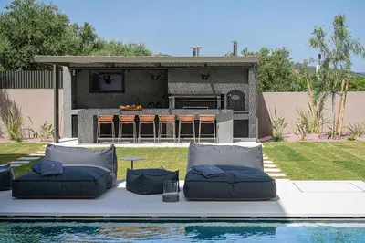 a swimming pool with two pillows and a table and a backyard at Villa Azahar Serene Luxury Living in Milonianá