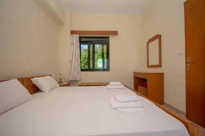 a bedroom with a large white bed with towels on it at Xenios Zeus Apartments in Kissamos