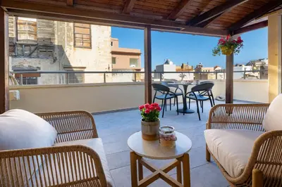 a patio with chairs and a table on a balcony at Ariadne de Potie Maisonette in Chania Town