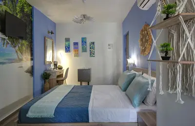 a bedroom with a large bed with blue walls at Elpida's Gοds in Chania Town