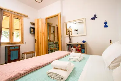 a bedroom with a pink bed and two folded towels at Mera Beachfront House - Falasarna in Falasarna