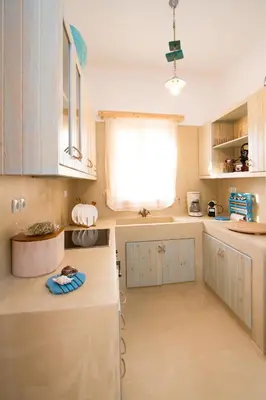 a kitchen with white cabinets and a window at Mera Beachfront House - Falasarna in Falasarna