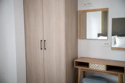 a bathroom with a wooden cabinet and a mirror at The Cozy Twins in Chania Town