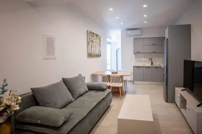 a living room with a couch and a kitchen at The Cozy Twins in Chania Town