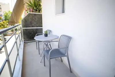 a patio with a table and chairs on a balcony at The Cozy Twins in Chania Town