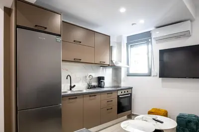 a kitchen with a stainless steel refrigerator and a sink at The Cozy Twins in Chania Town