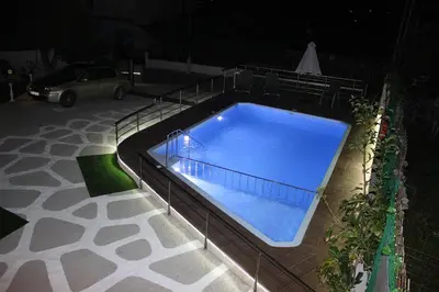 a swimming pool with a fence around it at night at Villa Sofia Filoxenia in Kalyves