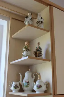 a shelving unit with shelves with tea pots and dolls at Villa Sofia Filoxenia in Kalyves