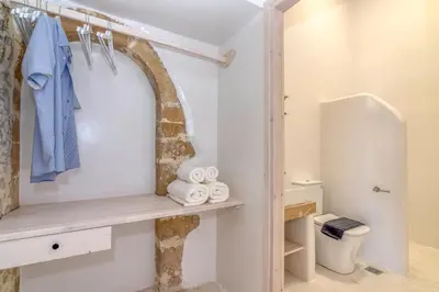 a bathroom with a toilet and a shelf with towels at The Mulberry Stonehouse Mountain - Sea View in Kalleryianá