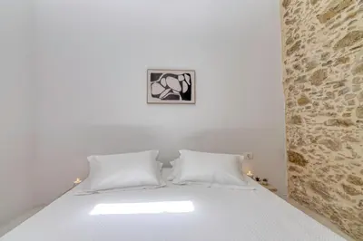 a white bed with two pillows in a bedroom at The Mulberry Stonehouse Mountain - Sea View in Kalleryianá