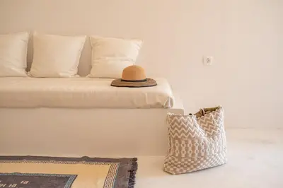 a hat sitting on top of a bed with a pillow at The Mulberry Stonehouse Mountain - Sea View in Kalleryianá