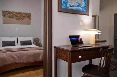 a bedroom with a bed and a desk with a laptop on it at Spiti an urban heaven in Chania Town