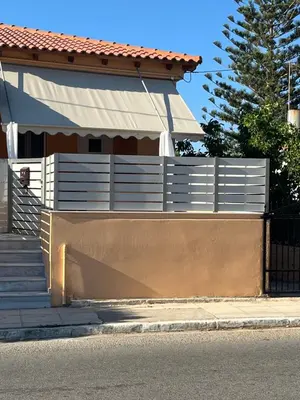 a white fence in front of a house at Two little olives Studio apartment in Kissamos