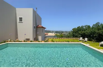 a swimming pool in front of a house at Kyparisses Villa with Private Pool in Chania Town
