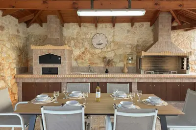 a dining room with a wooden table and chairs at Kyparisses Villa with Private Pool in Chania Town