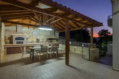a patio with a table and chairs and a kitchen at Kyparisses Villa with Private Pool in Chania Town
